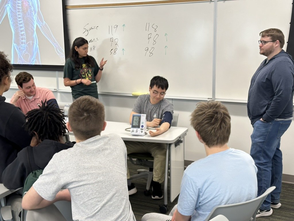Lab members demonstrate a live blood pressure stress response for visiting students