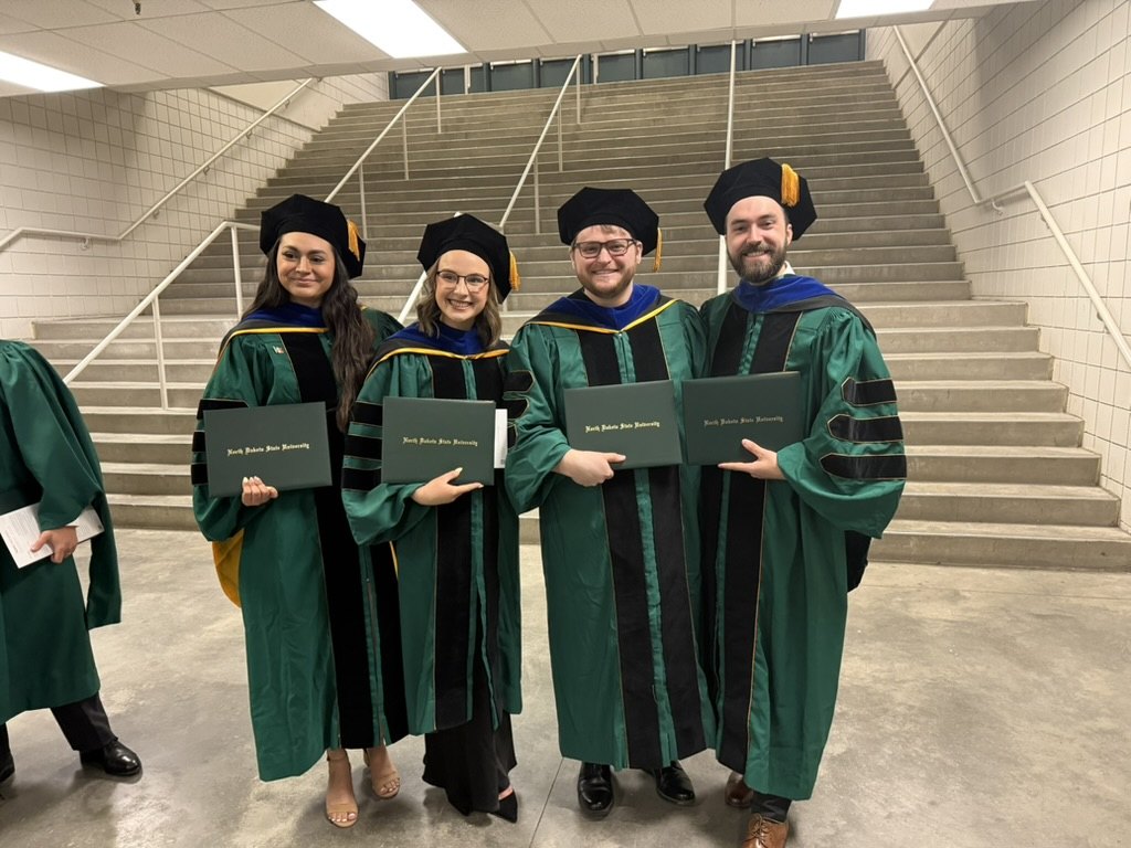 New NDSU Psychology Ph.D. graduates holding their diplomas