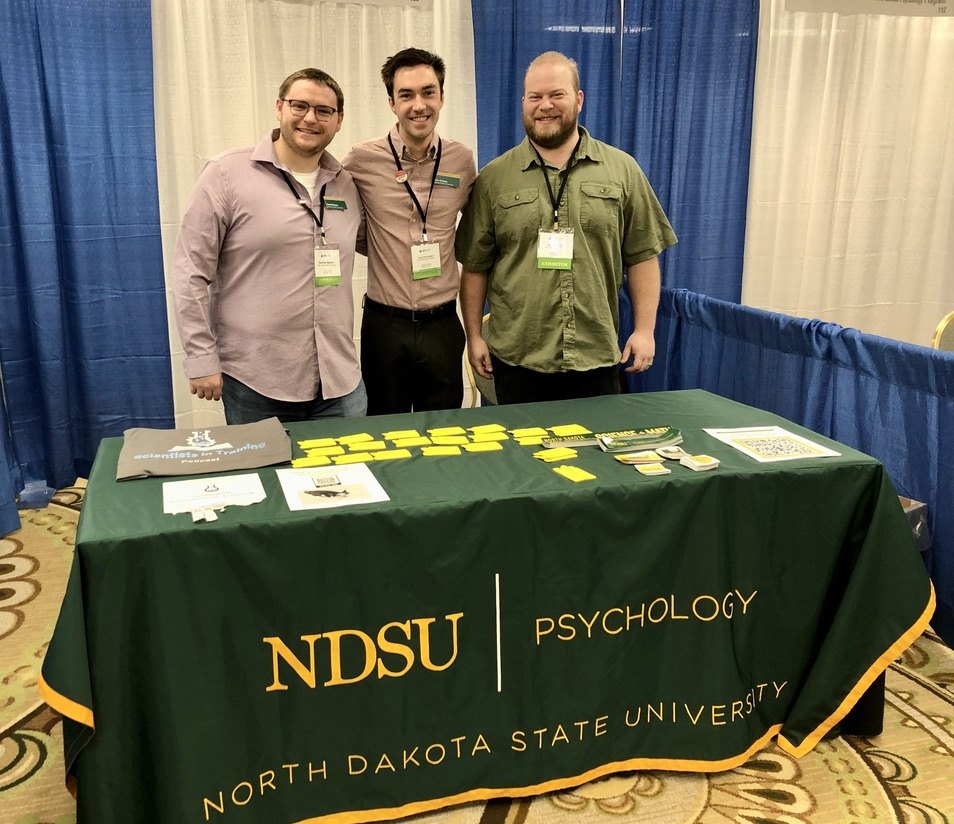 Three NDSU Psychology representatives at the department's exhibitor booth at the 2023 Midwestern Psychological Association meeting