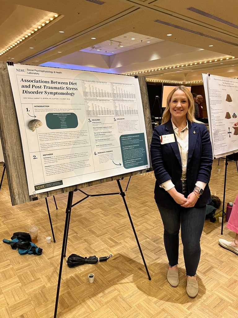 Jani with her poster, Associations Between Diet and Post-Traumatic Stress Disorder Symptomology, at the 2024 Red River Psychology Conference