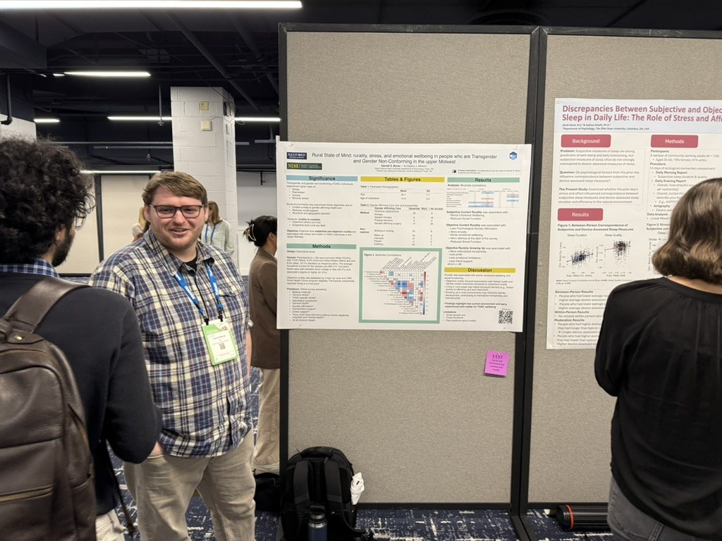 Garrett Byron discussing his poster with a visitor at the 2026 Society of Behavioral Medicine meeting