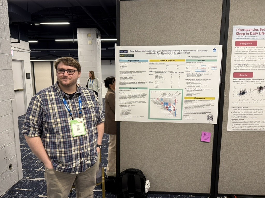 Garrett Byron with his poster, Rural State of Mind, at the 2026 Society of Behavioral Medicine meeting
