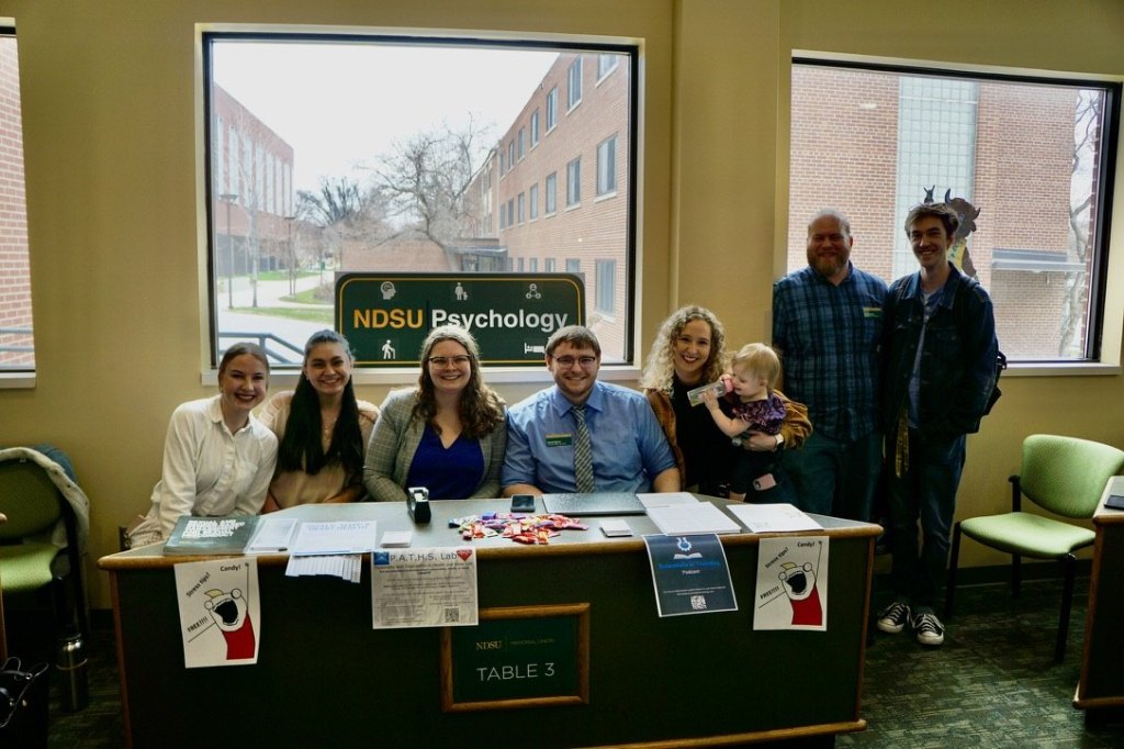 Psychology graduate students and faculty at the stress and sleep outreach table in the NDSU Memorial Union
